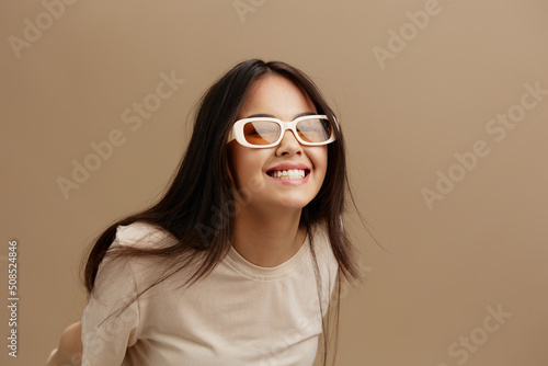 beautiful woman in a beige T-shirt with glasses posing clothing fashion isolated background © SHOTPRIME STUDIO