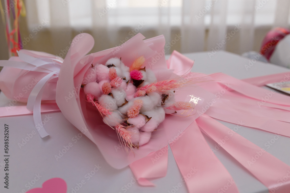 Flowers bouquet on white present box with pink ribbon and bow. Mothers, Valentines, women day, wedding, birthday