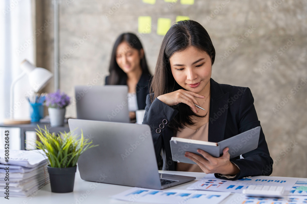 Young Asian businesswoman working online with laptop computer while sitting in office. Self-employed and freelance worker business activity concept Young Asian businesswoman working online with laptop computer while sitting in office. Self-employed and freelance worker business activity concept