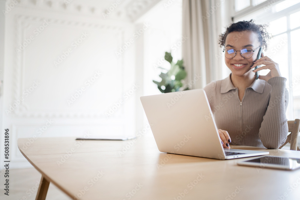 A female freelancer works in an office, uses a phone and a laptop computer, calls a client, talks about a project A female freelancer works in an office, uses a phone and a laptop computer, calls a client, talks about a project