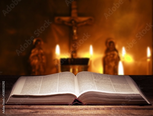 Open bible book on dark black wooden desk table space. Christ gospel literary.