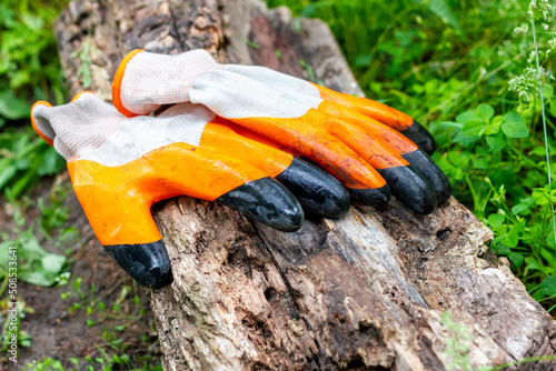 Wet rubberized gloves on a wooden stump. photo