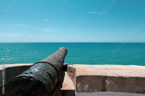 Old iron cannon pointing to the sea on the promenade of Sitges, a tourist city in the province of Barcelona, Catalonia, Spain