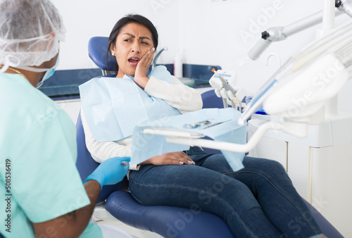 Professional doctor man talking with patient in medical chair