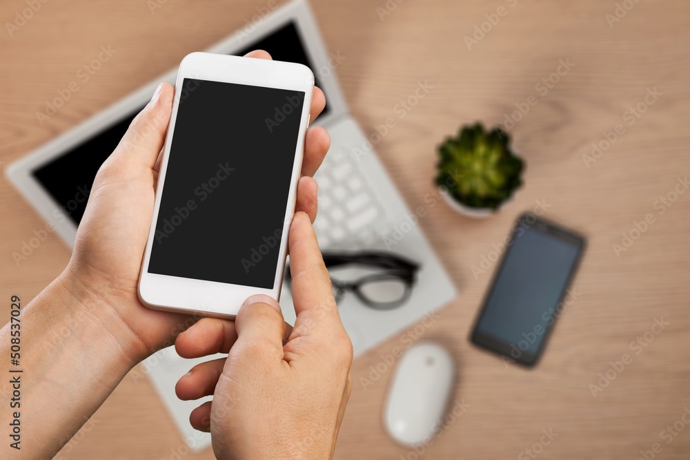 Man holding a smartphone with app on the screen on Office workplace.