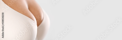 Obraz na płótnie Young woman in bra on light background with space for text, closeup