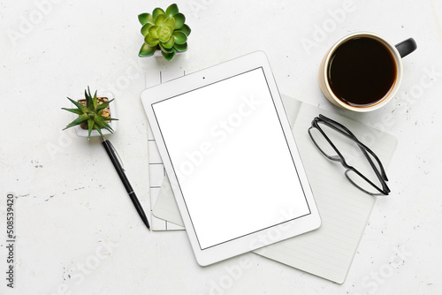 Composition with tablet computer, eyeglasses and cup of coffee on light background