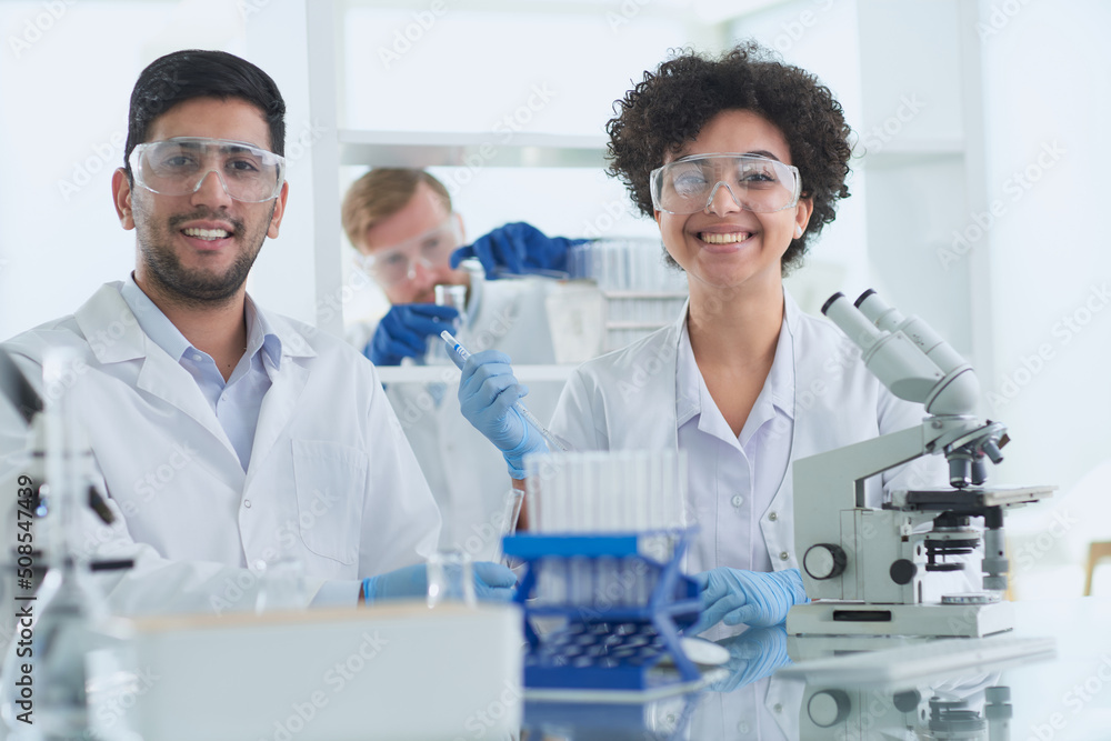 Smiling scientists looking at camera arms crossed in laboratory Smiling scientists looking at camera arms crossed in laboratory
