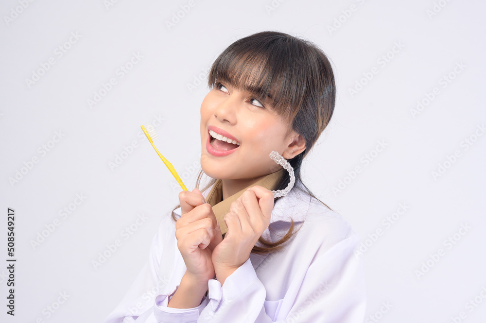 Young female dentist smiling over white background studio Young female dentist smiling over white background studio