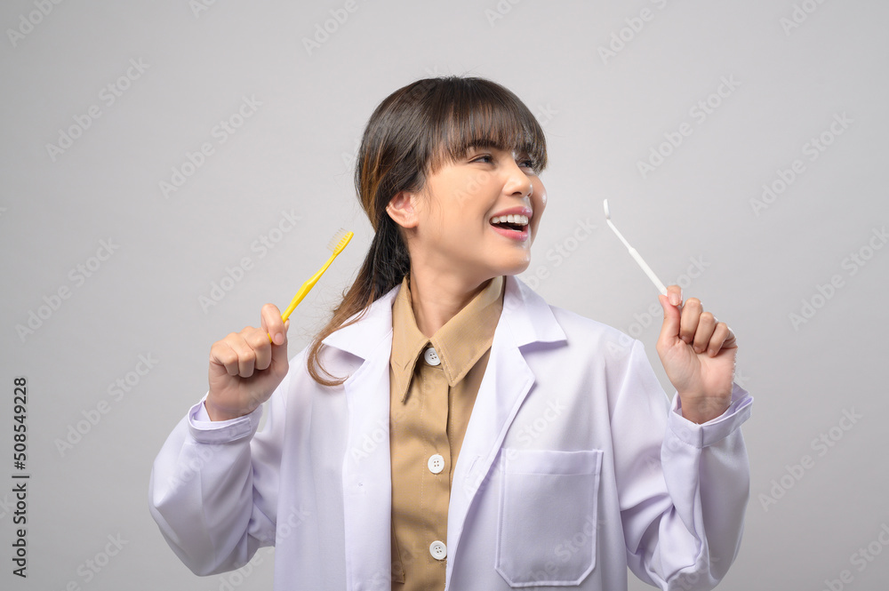 Young female dentist smiling over white background studio Young female dentist smiling over white background studio