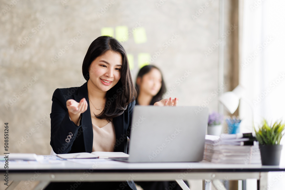 Portrait of Asian office employee businesswoman working in an office, doing planning analyzing the financial report, business plan investment, finance analysis concept. Office background. Portrait of Asian office employee businesswoman working in an office, doing planning analyzing the financial report, business plan investment, finance analysis concept. Office background.