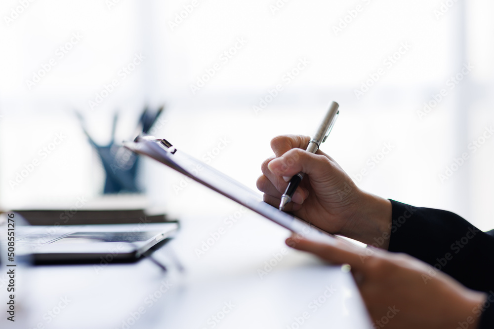 businesswoman Using calculator and tablet working at office with document on her desk, doing planning analyzing the financial report, business plan investment, finance analysis concept. businesswoman Using calculator and tablet working at office with document on her desk, doing planning analyzing the financial report, business plan investment, finance analysis concept.