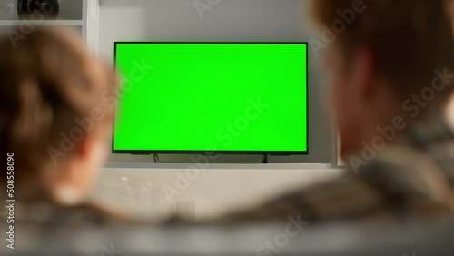 Wife zapping green tv screen switching channels. Family routine watching shows