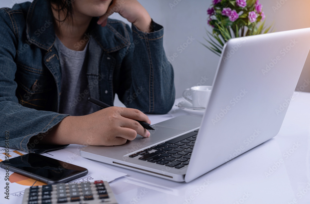 Naklejka premium Business woman working and watching the computer bored. Woman typing on her computer making use of technology. Stressed woman. Finger pressing on touchpad while her bored. lazy work.