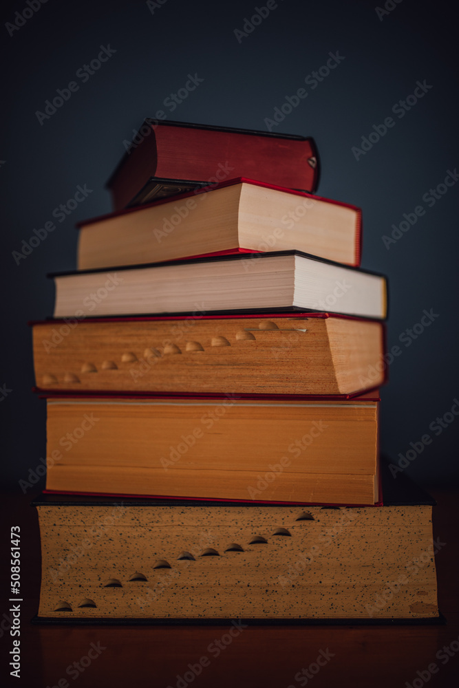 tall stack of five books against dark blue. copy space. tall stack of five books against dark blue. copy space.