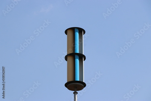 Vertical axis wind turbine or VAWT with blue sky in the background photo