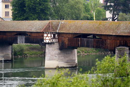 Covered wooden bridge over the Rhine River at Stein, Canton Aargau, and Bad Säckingen, Baden-Württemberg, on a cloudy spring day. Photo taken May 6th, 2022, Stein, Switzerland.