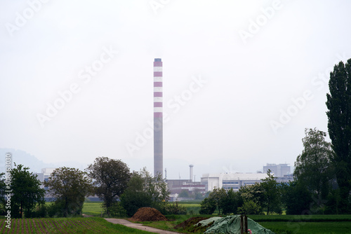 Industrial buildings with chimney at Village of Sisseln, Canton Aargau, on a cloudy spring day. Photo taken May 6th, 2022, Stein, Switzerland. photo