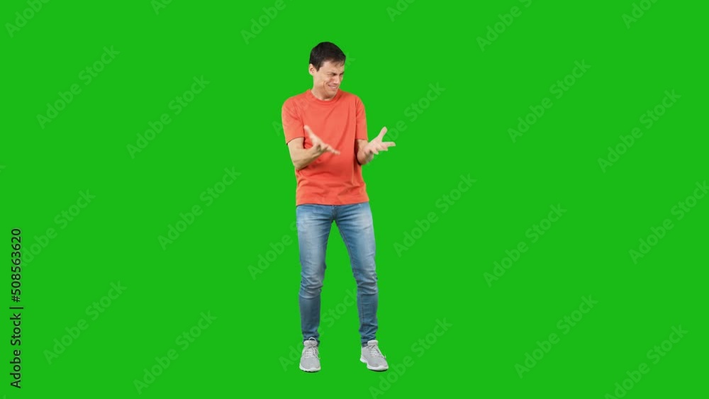 Shocked man pointing aside in studio. Green background Shocked man pointing aside in studio. Green background