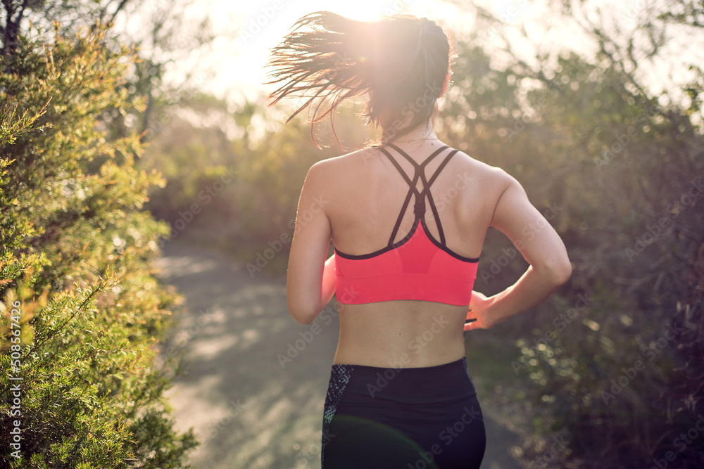 Fit Asian woman running for morning exercise, with lens flare Fit Asian woman running for morning exercise, with lens flare