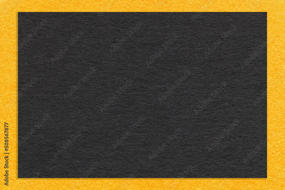 Fototapeta premium Texture of craft black paper background with yellow border, macro. Structure of vintage dense kraft cardboard