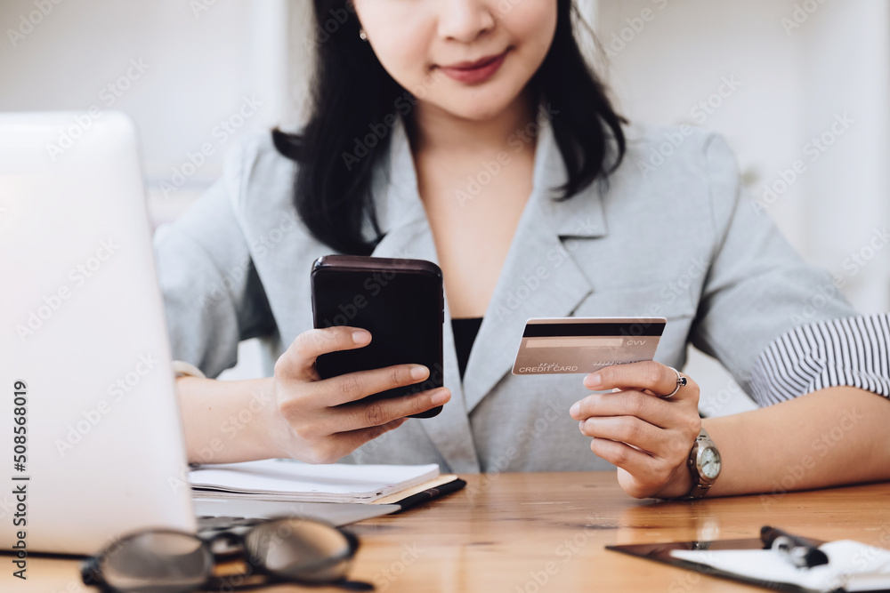 Online Shopping and Internet Payments, Asian man are using their credit card and mobile phone to shop online or conduct errands in the digital world. Online Shopping and Internet Payments, Asian man are using their credit card and mobile phone to shop online or conduct errands in the digital world.