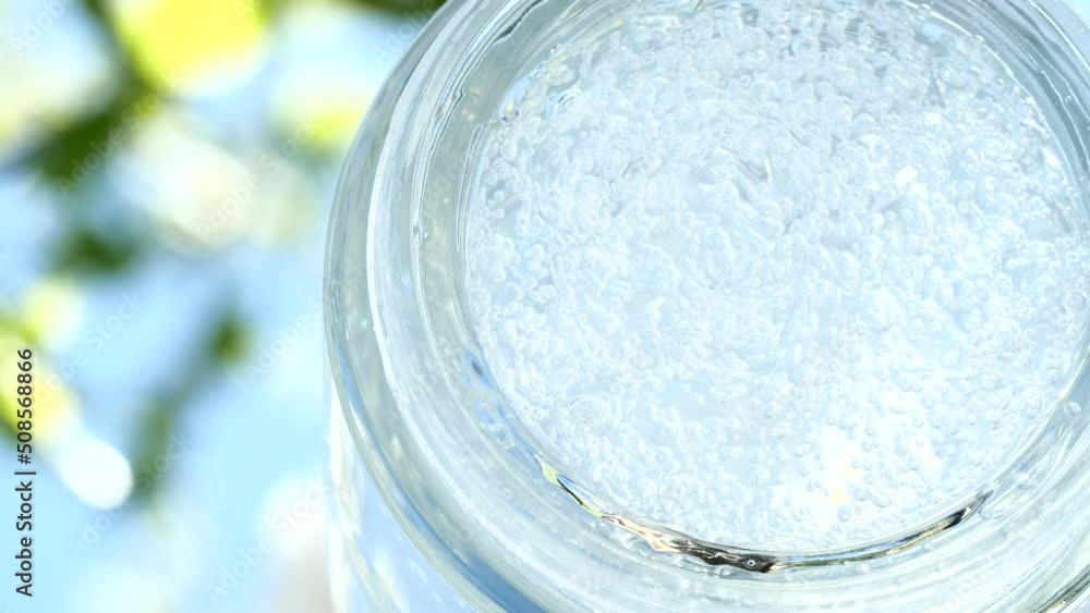 Macro transparent cosmetic serum gel, cream, fluid texture, closeup white flower Macro transparent cosmetic serum gel, cream, fluid texture, closeup white flower