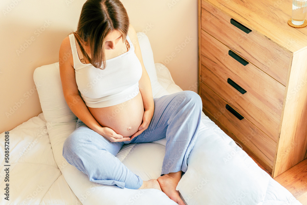 Healthy pregnancy meditation. Beautiful pregnant woman meditating while sitting in lotus position. Health yoga home sport. Pregnancy, maternity, healthcare concept. Healthy pregnancy meditation. Beautiful pregnant woman meditating while sitting in lotus position. Health yoga home sport. Pregnancy, maternity, healthcare concept.