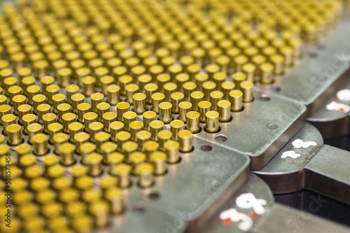 Set of golden bullet shells in metal cartridges on stand