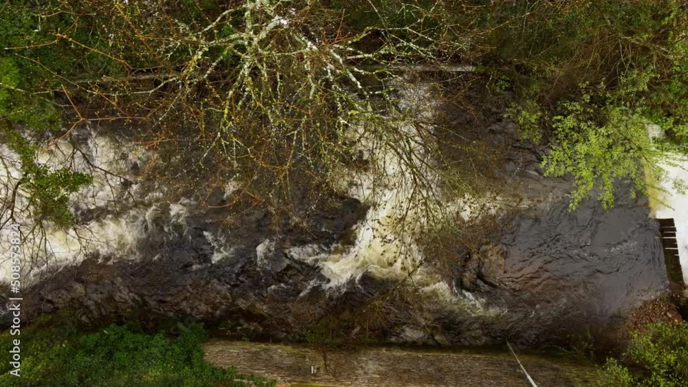 Amazing landscape of beautiful waterfall on mountain river with white foamy water falling down from rocky cliff Amazing landscape of beautiful waterfall on mountain river with white foamy water falling down from rocky cliff