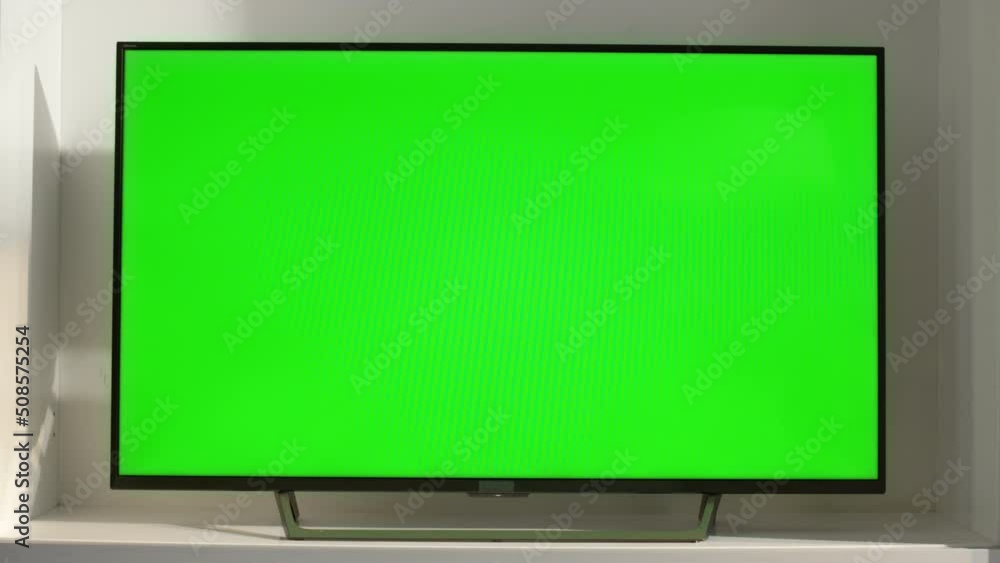 Chroma key smart TV in living room closeup. Device with blank screen in sunlight Chroma key smart TV in living room closeup. Device with blank screen in sunlight