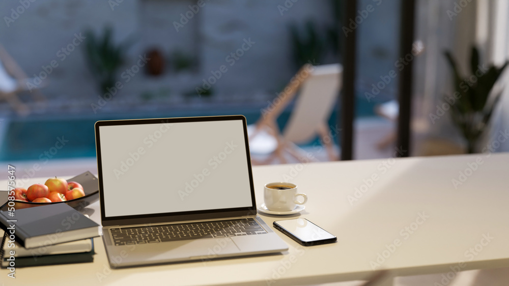 Notebook laptop and copy space on white tabletop house over blurred pool in background. Notebook laptop and copy space on white tabletop house over blurred pool in background.