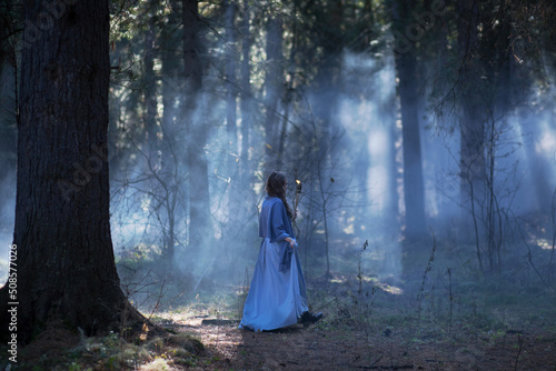 Girl with a torch in the forest. The girl got lost in the forest. Torch.