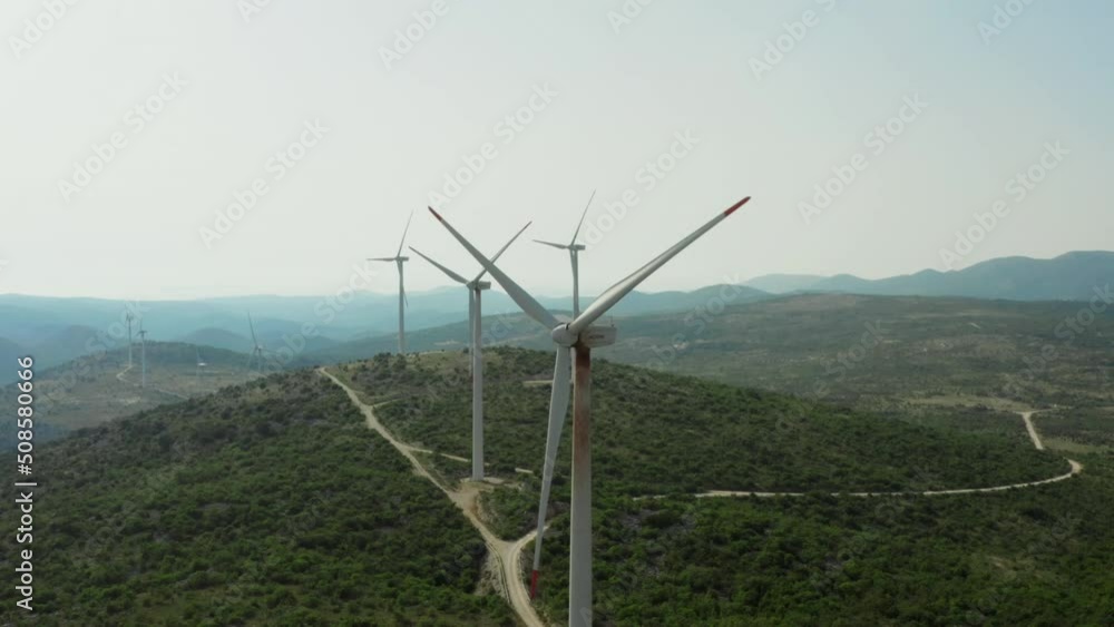Aerial view of industrial windmills in the mountains. Wind power generation, beautiful scenery and windmill blades are spinning. Aerial view of industrial windmills in the mountains. Wind power generation, beautiful scenery and windmill blades are spinning.