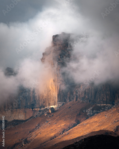 High mountain cliff with low clouds in Caucasus region in Russia