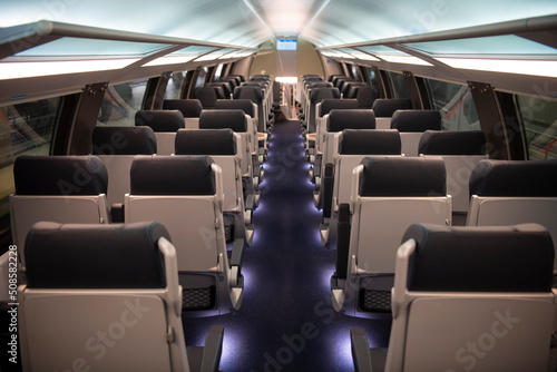 Empty comfortable modern seats inside business class cabin of fast speed European train. Interior of high speed train compartment.