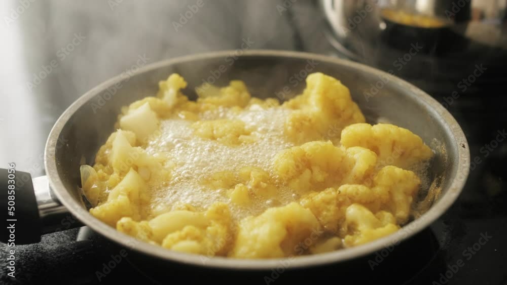 Cauliflower fried in pan close up shot. Vegan cuisine, cauliflower recipe. Homemade dish. Healthy food concept. Cauliflower fried in pan close up shot. Vegan cuisine, cauliflower recipe. Homemade dish. Healthy food concept.