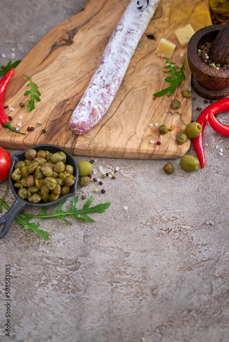 Spanish sausage fuet salami and vegetables on a domestic kitchen photo