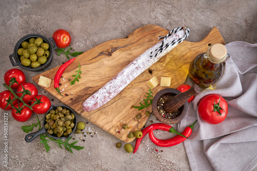 Spanish sausage fuet salami and vegetables on a domestic kitchen photo