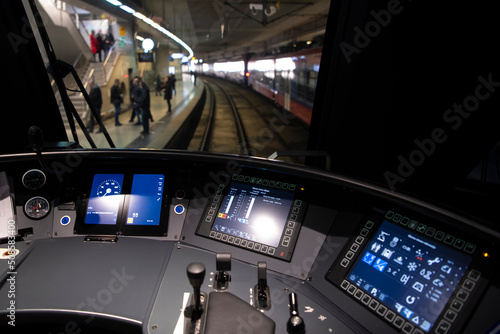 Empty train cabin of driver. Interior of control place of fast train with dashboard, buttons and monitors standing on railway station. Cockpit view of high speed modern train.