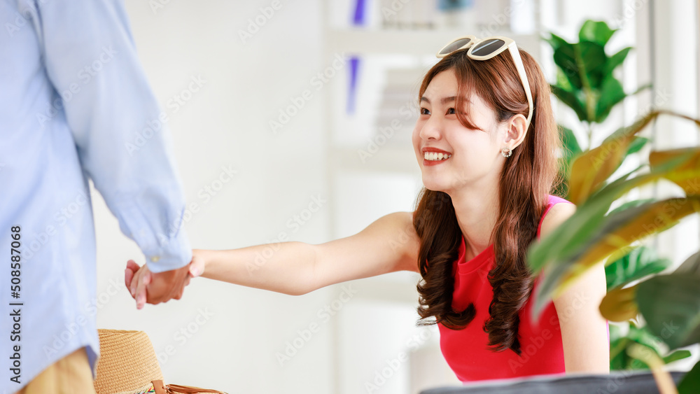 Asian pretty cheerful happy female girlfriend traveler in casual summer outfit with sunglasses holding hand with unrecognizable unknown male lover boyfriend while wait for departure for vacation trip Asian pretty cheerful happy female girlfriend traveler in casual summer outfit with sunglasses holding hand with unrecognizable unknown male lover boyfriend while wait for departure for vacation trip