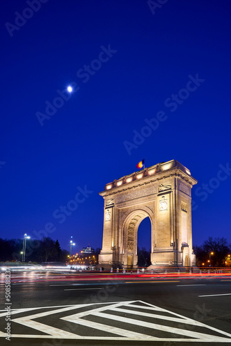 The Arcul de Triumf, a triumphial arch in Bucharest, Romania, at night photo
