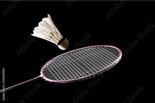 badminton racket and shuttlecock isolated on black background photo
