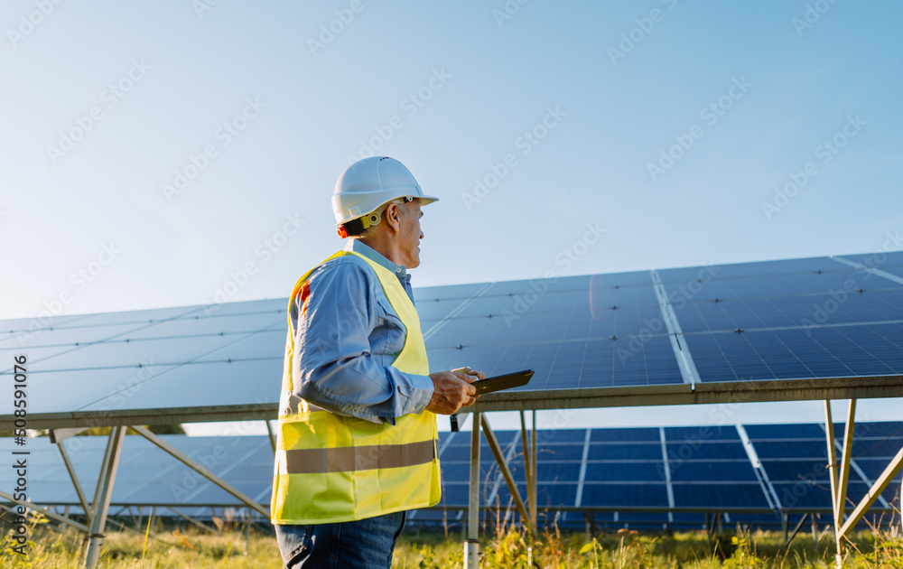 Worker checking solar panels with tablet in solar farm. Eco energy Worker checking solar panels with tablet in solar farm. Eco energy