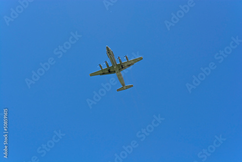 The plane is gaining altitude against the blue sky on a clear summer day