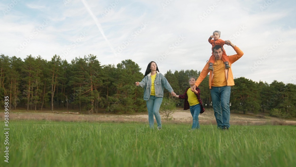 people in the park. happy family a walk at sunset. mom dad and daughter walk holding hands in the park life. happy family kid dream concept. parents and baby fun walking forest park people in the park. happy family a walk at sunset. mom dad and daughter walk holding hands in the park life. happy family kid dream concept. parents and baby fun walking forest park