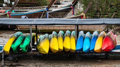 Numerous colorful kayaks stacked for storage
