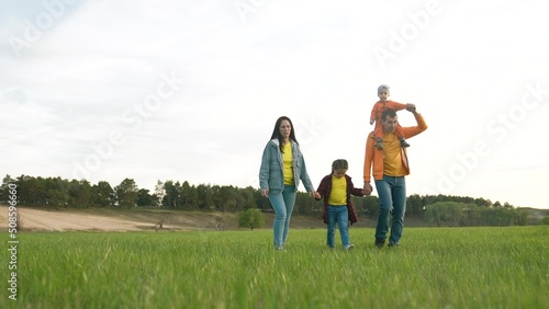 people in the park. life happy family a walk at sunset. mom dad and daughter walk holding hands in the park. happy family kid dream concept. parents and baby fun walking forest park