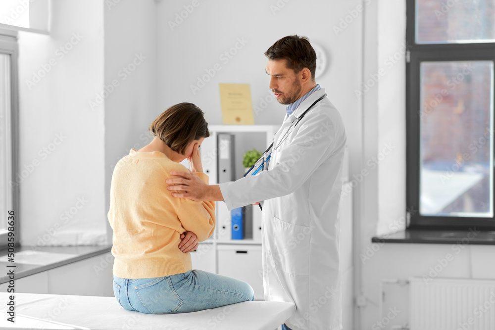 medicine, healthcare and people concept - male doctor with clipboard comforting sad woman patient having health problem at hospital medicine, healthcare and people concept - male doctor with clipboard comforting sad woman patient having health problem at hospital