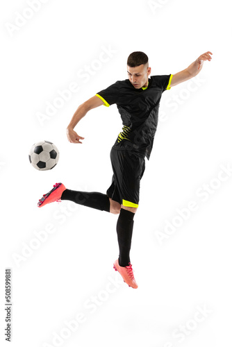 Dynamic portrait of professional male football soccer player training isolated on white studio background. Concept of sport, goals, competition, hobby, achievements © master1305